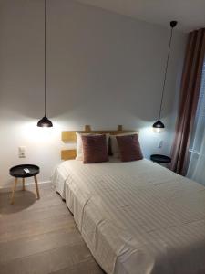 a bedroom with a large white bed with two lamps at Halal Kuca sa bazenom u Mostaru in Mostar