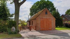 a small brick building with a large wooden door at Haus Am See in Manhagen