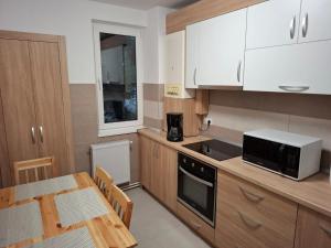 a kitchen with white cabinets and a table and a microwave at The Future Residence in Sfântu-Gheorghe