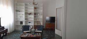 a living room with two chairs and a table and a television at Ravenna Suite in Ravenna