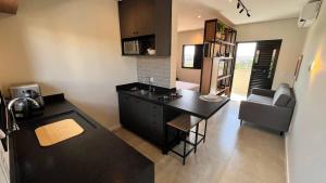 a kitchen with a black island in a room at Voá Flat in Capivari