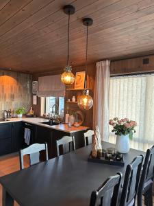 a kitchen with a table and chairs in a kitchen at Flott hytte med høy standard og unik utsikt in Lensvik