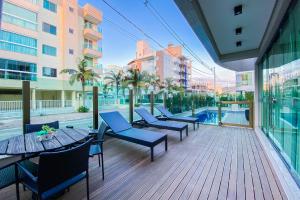 a deck with tables and chairs on a building at Apartamento super completo a 250mts do mar in Governador Celso Ramos