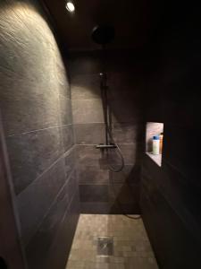 a bathroom with a shower in a dark room at Flott hytte med høy standard og unik utsikt in Lensvik