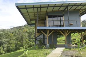 a house on top of a hill with trees at Arenal Hideaway in San Ramón