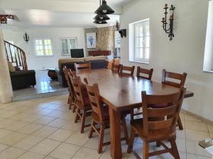 a dining room with a wooden table and chairs at Villa com piscinas - Quintinha do Lago in Quarteira