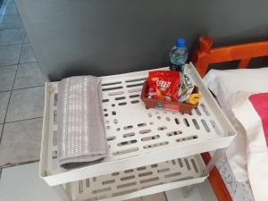 a white basket with food and drinks on a bed at Vivendas do Trabalhador in São Francisco do Sul +7 photos