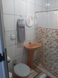a bathroom with a toilet and a sink and a mirror at Vivendas do Trabalhador in São Francisco do Sul