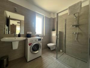 a bathroom with a washing machine and a sink at Sophia Apartman Gödöllő in Gödöllő +45 photos