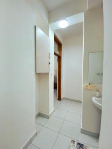 ein weißes Badezimmer mit Waschbecken und Spiegel in der Unterkunft Three Bedroom A2 Buxton Mombasa in Mombasa