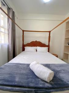 ein Kissen, das auf einem Bett in einem Schlafzimmer liegt in der Unterkunft Three Bedroom A2 Buxton Mombasa in Mombasa + 16 Fotos