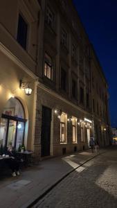 a building at night with people sitting at tables outside at Crown Pearl - wonderful apartment, 110scm, 4 rooms in Kraków