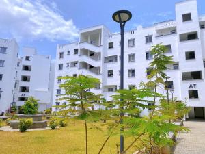 a white building with a tree in front of it at Bahari Three Bedroom Mombasa in Mombasa