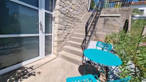 un tavolo e sedie blu su un patio con scale di Charmant T2 neuf haut de gamme a Brive-la-Gaillarde