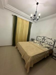 een slaapkamer met een bed met een kroonluchter bij S1 vue de mer in Chott Meriem