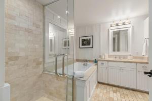 a bathroom with a shower and a tub and a sink at Villa 102 at Turtle Bay in Kahuku +31 photos