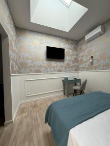 une chambre avec un lit et une télévision au mur dans l'établissement Via Polonia - Boutique Studios Corfu, à Ágios Geórgios