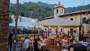 a group of people sitting at tables at a restaurant at Toscana Made in Love in Massa