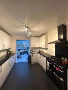 a kitchen with white cabinets and a stove top oven at Carden Villa 4 Bedroom House With Hot Tub Pet Friendly in Brighton & Hove