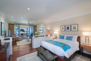 a bedroom with a large bed and a living room at Villa 317 at Turtle Bay in Kahuku +34 photos