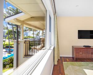 a room with a balcony with a view of the pool at 3-Bed Villa 313 at Turtle Bay in Kahuku