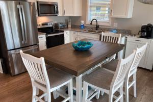 a kitchen with a wooden table with chairs and a refrigerator at Sunset Revival in St. George Island