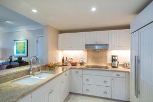 a kitchen with white cabinets and two sinks at 3-Bed Villa 316 at Turtle Bay in Kahuku