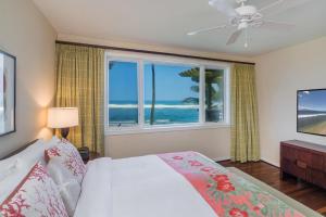 a bedroom with a bed and a window with the ocean at 3-Bed Villa 316 at Turtle Bay in Kahuku +36 photos