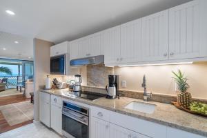 una cucina con mobili bianchi e un lavandino di 4-Bed Combination Villa 316-317 Turtle Bay a Kahuku