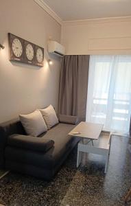 ein Wohnzimmer mit einem Sofa, einem Tisch und Uhren in der Unterkunft Thissio Hideaway Suite in Athen + 14 Fotos
