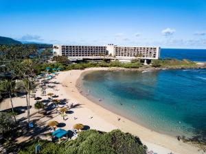 a view of a beach with umbrellas and the ocean at Villa 305 at Turtle Bay in Kahuku
