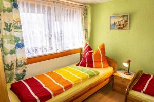 ein Schlafzimmer mit einem Bett mit bunten Kissen darauf in der Unterkunft Haus Kerstin, Ferienreihenhaus in Westfehmarn