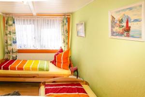 ein kleines Zimmer mit einem Bett und einem Fenster in der Unterkunft Haus Kerstin, Ferienreihenhaus in Westfehmarn + 14 Fotos