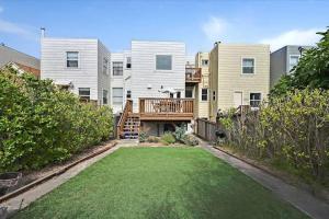 a yard in front of a apartment building with a deck at Spacious SF Haven - Cozy Bedrooms & Modern Kitchen in San Francisco
