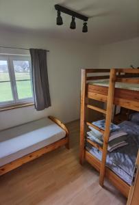 two bunk beds in a room with a window at Niedergerner Alpaka Ranch Groß in Kemerting