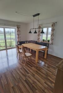 a dining room with a wooden table and chairs at Niedergerner Alpaka Ranch Groß in Kemerting