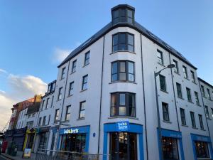 a white building on a city street at Coastal Links, Main Street Portrush, 1 to 5 guests in Portrush