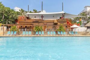 圣玛尔塔加连得可麦仑酒店 - 全包的一个带椅子的游泳池，后面有一艘海盗船