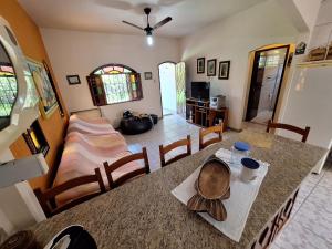a kitchen and living room with a table and a bed at Casa Mega confortável a pé da Praia Pereque Angra in Angra dos Reis