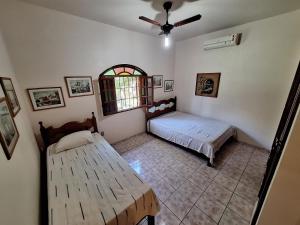 a bedroom with two beds and a window at Casa Mega confortável a pé da Praia Pereque Angra in Angra dos Reis