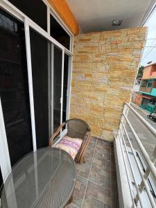a glass table and a chair on a balcony at Zihua 360 in Zihuatanejo