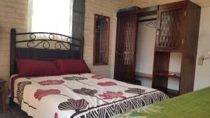 a bedroom with a bed with a floral comforter at Zihua 360 in Zihuatanejo