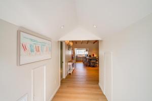 a hallway of a home with white walls and wooden floors at Victorian Carpinteria Apartment Less Than 1 Mi to Beach! in Carpinteria