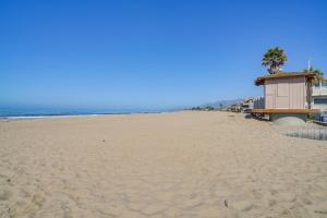 a beach with a lifeguard house and palm trees at Victorian Carpinteria Apartment Less Than 1 Mi to Beach! in Carpinteria