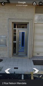 a front door of a building with a blue door at Piso camino a Fisterra in Negreira