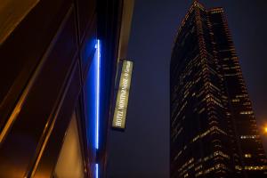 um sinal azul no lado de um edifício alto em Hôtel Montparnasse Saint Germain em Paris