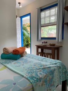 um quarto com uma cama, uma janela e uma mesa em Pousada do Beijaflor em Florianópolis