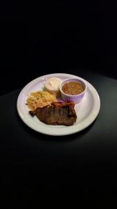 une assiette de nourriture avec de la viande et un bol de soupe dans l'établissement Motel Zurich 5, à São Paulo