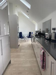 a kitchen with white cabinets and a counter top at The Old School House - 6 Postland Road, Crowland in Crowland
