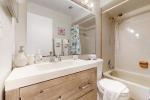 a bathroom with a sink and a toilet and a mirror at SEA STAR in Cape Canaveral +24 photos